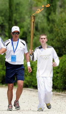 ATHENS, GREECE - MAY 10: Alex Loukas from Britain carries the London 2012 Olympic Torch during the Lighting Ceremony of the Olympic Flame at Ancient Olympia on May 10, 2012 in Olympia, Greece. (Photo by Jamie McDonald/Getty Images)