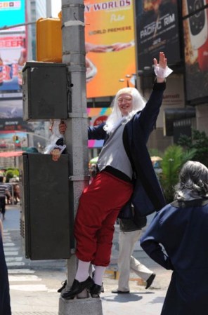 Un actor vestido de Benjamin Franklin en Times Square, con una sensual y alocada pose.