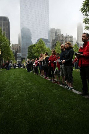 NEW YORK, NY - MAY 15: People watch a live video from the Ground Zero memorial site of the dedication ceremony of the National September 11 Memorial Museum in New York May 15, 2014 in New York City. The museum spans seven stories, mostly underground, and contains artifacts from the attack on the World Trade Center Towers on September 11, 2001 that include the 80 ft high tridents, the so-called "Ground Zero Cross," the destroyed remains of Company 21's New York Fire Department Engine as well as smaller items such as letter that fell from a hijacked plane and posters of missing loved ones projected onto the wall of the museum. The museum will open to the public on May 21. (Photo by Spencer Platt/Getty Images)