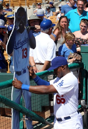 Yasiel Puig #66 de Los Angeles Dodgers con una foto de Hanley Ramírez.
