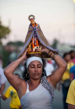 17 DE DICIEMBRE DE 2012: Una mujer devota de San Lázaro carga una imagen del santo en las festividades religiosas celebradas en El Rincón, La Habana.