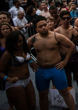NEW YORK, NY - AUGUST 05: A man wearing only his underwear dances in front of a crowd in Times Square in an attempt to break the Guinness Book of World Records' record for "the most amount of people gathered in their underwear in the Times Square section of New York" on August 5, 2013 in New York City. Organizers were hoping to get 2,271 people to strip down to their underwear - the current record is 2,270. (Photo by Andrew Burton/Getty Images)