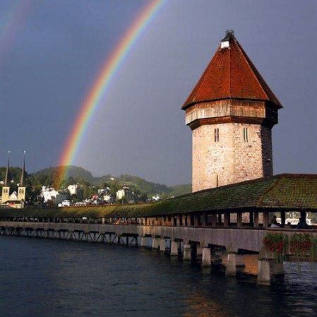 El Puente de la Capilla de Lucerna mide 204 m.(670 pies) de largo y que cruza el río Reuss. The Chapel Bridge es el más antiguo puente de madera cubierto en Europa, y uno de los principales atractivos turísticos de Suiza.
