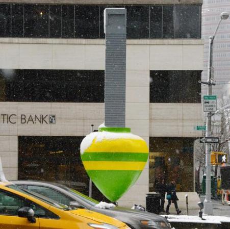 El edificio de Citigroup bailando sobre trompo verde y amarillo.
