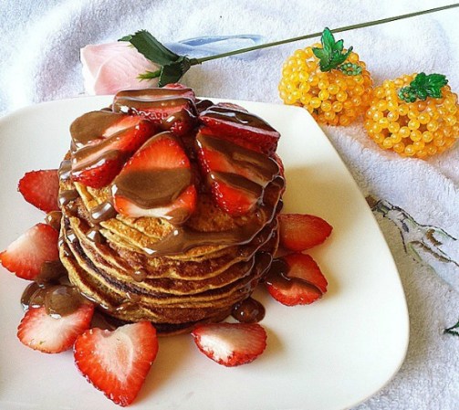 Hot cakes con mantequilla de cacahuate, miel y fresas.