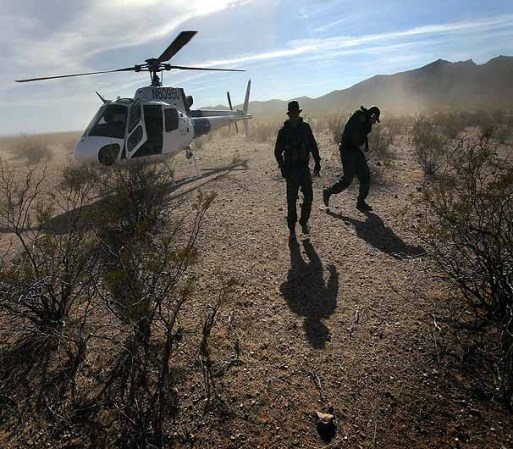TOHONO O'ODHAM NATION, AZ - DECEMBER 09: Border Patrol agents deplane a helicopter from the U.S. Office of Air and Marine after searching for drug smugglers spotted in a remote area of the Sonoran Desert on December 9, 2010 in the Tohono O'odham Reservation, Arizona. The area is a favorite spot for smugglers and illegal immigrants to cross the border into the United States. (Photo by John Moore/Getty Images)