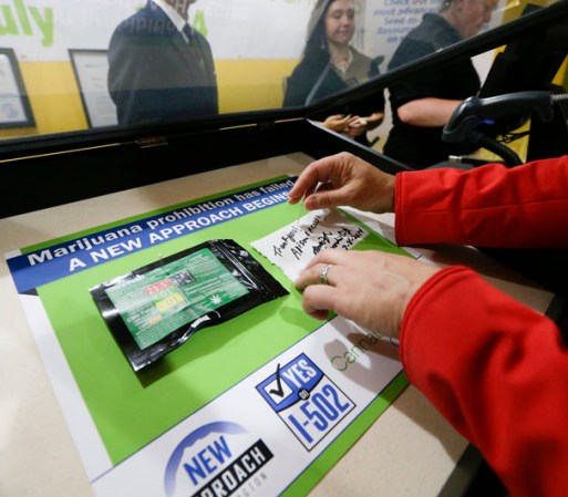 Alison Holcomb, de la ACLU, compra marihuana en Cannabis City durante el primer día de ventas en Washington.
