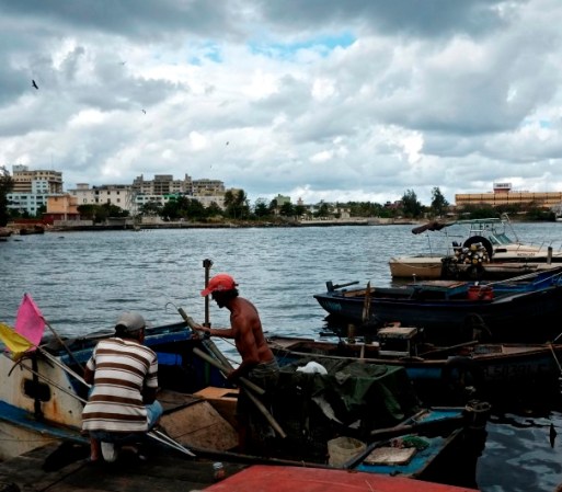 Pescadores trabajan en sus botes en uno de los muelles locales.