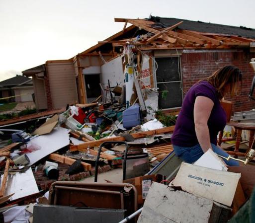 ARLINGTON, TX - APRIL 03: April Bridges searches through the remains of a house she at when it was destroyed by a tornado on April 3, 2012 in Arlington, Texas. Multiple tornadoes touched down across the Dallas/Fort Worth area causing extensive damage. (Photo by Tom Pennington/Getty Images)