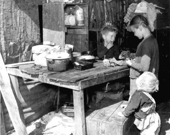 Hijos de trabajadores de las empacadoras, que viven en un "cobertizo" hecho de pedazos de lata oxidada, galvanizada y de arpillera. Ellos se quedan solos durante todo el día y muchas veces hasta la madrugada. Ambos padres trabajan cuando les es posible. Belle Glade, Florida, 1939.