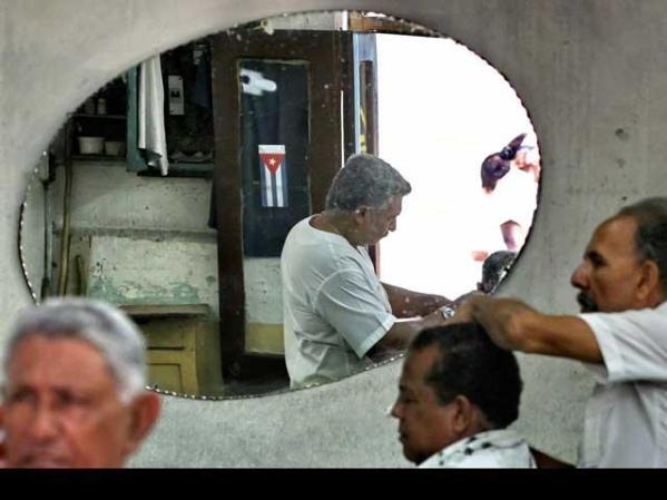 Pedro Veliz (espejo) y su hermano Andrés Veliz (derecha) tienen una barbería en Santiago.