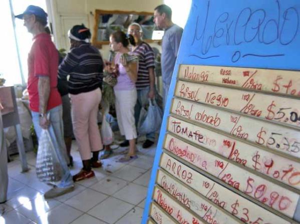 Cubanos compran vegetales en un mercado de Guines.