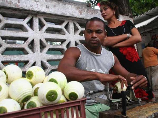 Luis Orlando Lamot pela y vende cítricos en una esquina de La Habana.