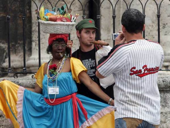 Cubana con traje típico se gana los pesos retratándose con turistas frente a la Catedral.