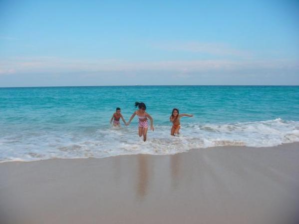 bambinos que juegan en playa de mar azul