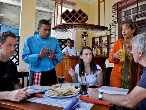 10 DE ENERO, 2011: Javier Martínez habla con turistas en su "paladar" Habaname. Estos restaurantes se han multiplicado en la isla.