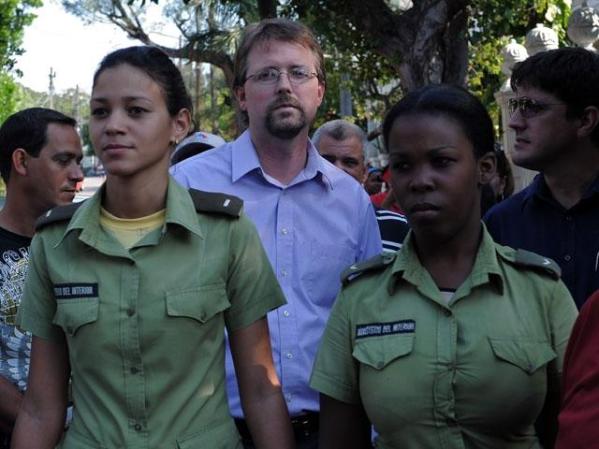 28 DE FEBRERO, 2011: El diplomático de Estados Unidos Lowell Dale Lawton, es protegido de la turba mientras observa una marcha de las Damas de Blanco.