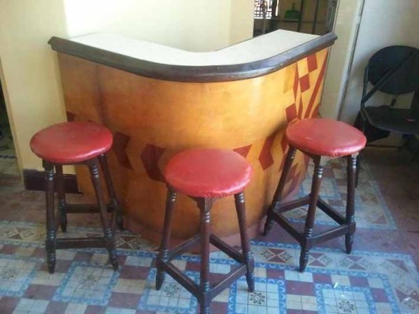 Mueble bar con tres banquetas torneadas.