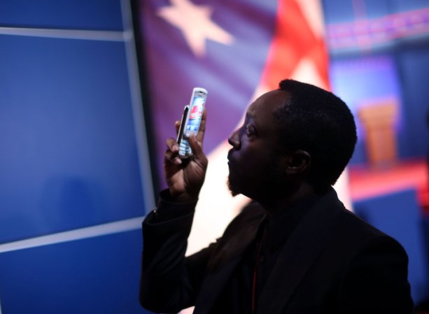 Will.i.am toma fotos con su teléfono.