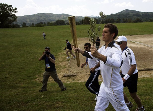 ATHENS, GREECE - MAY 10: Spyros Gianniotis of Greece holds the London 2012 Olympic Torch during the Lighting Ceremony of the Olympic Flame at Ancient Olympia on May 10, 2012 in Olympia, Greece. (Photo by Milos Bicanski/Getty Images)