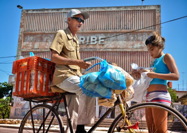 22 DE ABRIL, 2012: En vendedor de pan se busca la vida por las calles de La Habana, y ha encontrado a una compradora.