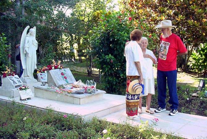 Ramón Castro y dos de sus hermanasante la tumba e su madre, Lina Ruz, en el 2003..