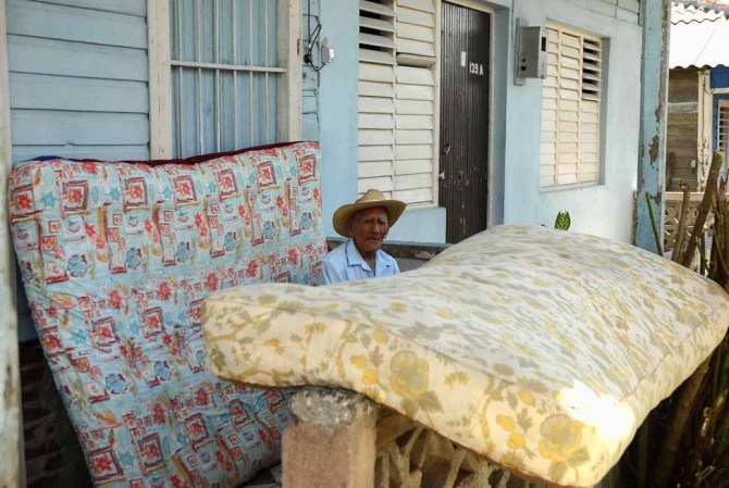 26 DE OCTUBRE DE 2012: Un hombre descansa frente al portal de una vivienda luego del paso del huracán Sandy por el poblado de Antilla, en la provincia de Holguín.