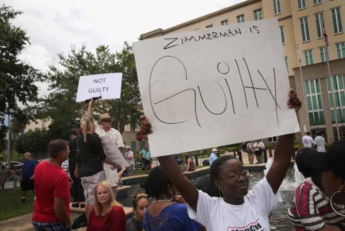 SANFORD, FL - JULY 13: Supporters of Treyvon Martin and George Zimmerman demonstrate in front of the Seminole County Criminal Justice Center as they wait for the verdict to be announced in the George Zimmerman murder trial on July 13, 2013 in Sanford, Florida. The jury found Zimmerman, a neighborhood watch volunteer, not guilty in the February 2012 shooting death of 17-year-old Treyvon Martin. (Photo by Scott Olson/Getty Images)
