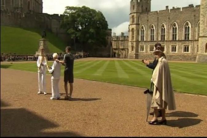 A las puertas del complejo se agolpaban cientos de personas para ver salir la llama olímpica tras su visita a la soberana británica.