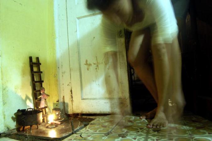 ISLA DE LA JUVENTUD, CUBA -Una mujer hace una ofrenda en un altar.