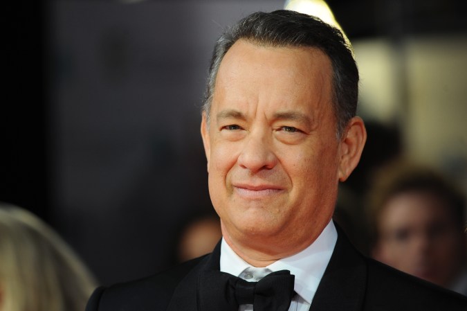 En 1993 Tom Hanks desprevenidamente puso en evidencia a su maestro gay de drama de la escuela secundaria, al agradecerle por ser su inspiración para el papel que representó en “Philadelphia”; un incidente que se convirtió en la base del filme "In & Out".
