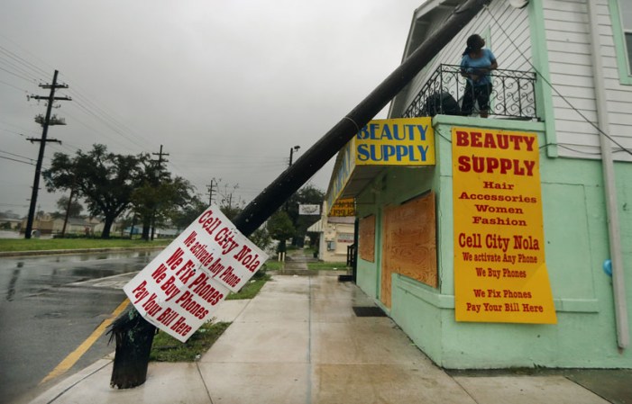 Una mujer observa el poste de teléfono que cayó sobre una casa en Nueva Orleans debido al paso de Isaac.