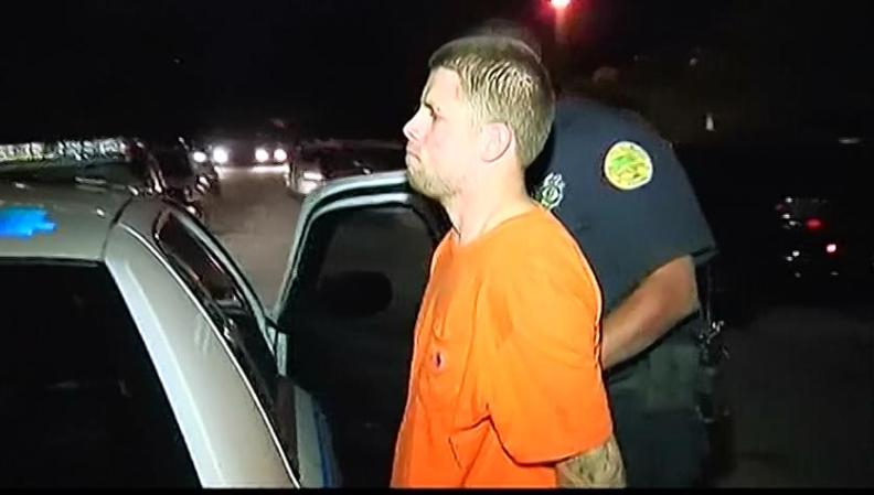 Joan Raúl Domínguez en el momento en que es introducido en la patrulla policíaca tras su arresto.