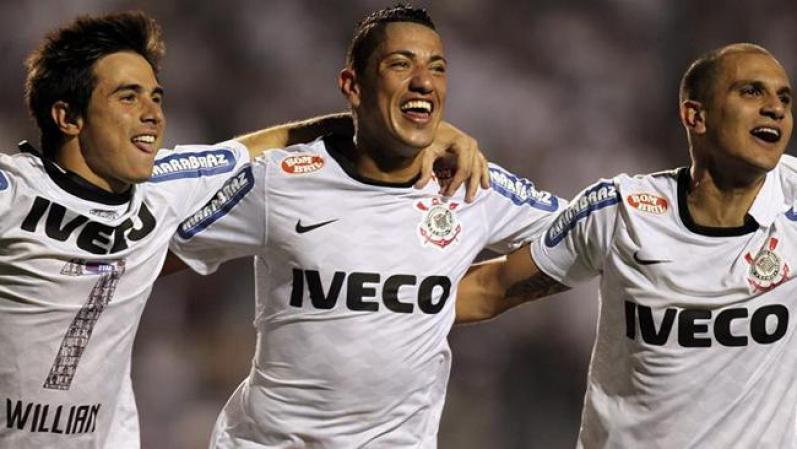 Los jugadores de Corinthians William (i), Ralf (c) y Fabio Santos (d) celebran tras la victoria del equipo ante Boca Juniors en el partido de vuelta de la final de la Copa Libertadores de América en el estadio de Pacaembú de Sao Paulo,