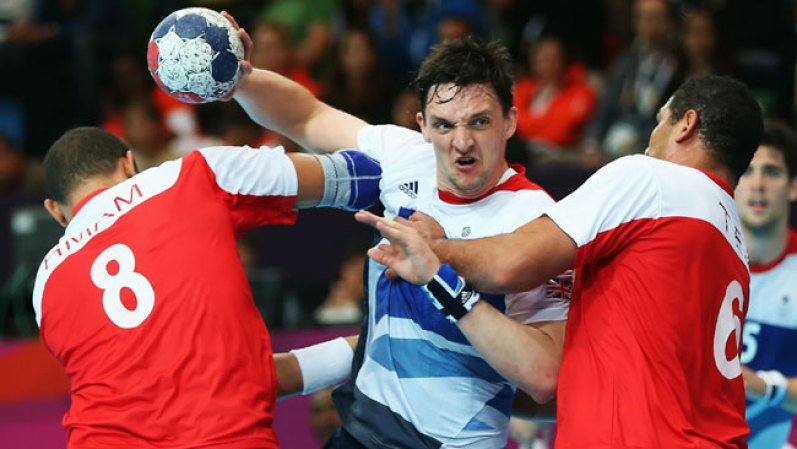 Christopher McDermott, el número 21 del equipo de Handball de Gran Bretaña defiende con todos los hierros ante Wissem Hmam, a la izquierda en el partido ante Túnez.