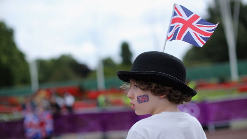Un niño británico apoya al equipo femenino de ciclistas durante el triatlón,uno de los desafíos más difíciles.