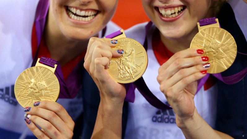 Dani Rey, Laura Trott, y Joanna Rowsell de Gran Bretaña, posan con su medalla de oro durante la ceremonia de premiación. Ganaron persecuión por equipos, rompieron récord mundial. El detalle de las uñas y los colores de su país.