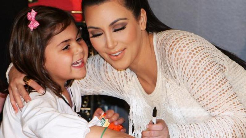Kim firma un autógrafo a una joven fan.