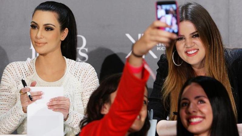 Kim y Khloe Kardashian son fotografiadas por sus admiradoras.