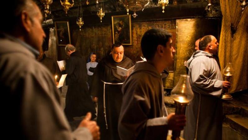 Un grupo de monjes eleva rezos dentro de la Iglesia de la Natividad en Belén.