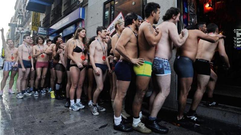 MADRID, SPAIN - JANUARY 02: Semi-nude shoppers enter a Spanish clothes outlet for free clothes during a promotion on January 2, 2012 in Madrid, Spain. The first one hundred semi-nude shoppers were alllowed free clothes on the first day of the January sales. (Photo by Denis Doyle/Getty Images)