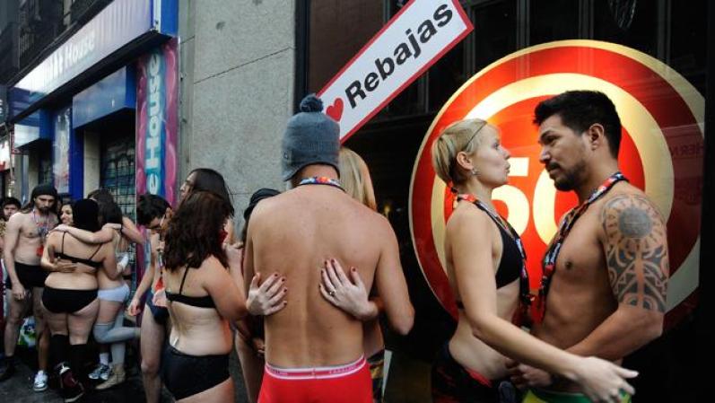 MADRID, SPAIN - JANUARY 02: Semi-nude shoppers queue for free clothes during a promotion by a Spanish clothes outlet on January 2, 2012 in Madrid, Spain. The first one hundred semi-nude shoppers were alllowed free clothes on the first day of January sales. (Photo by Denis Doyle/Getty Images)