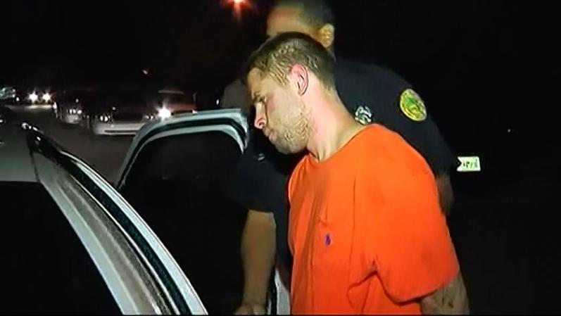 Joan Raúl Domínguez en el momento en que es introducido en la patrulla policíaca tras su arresto