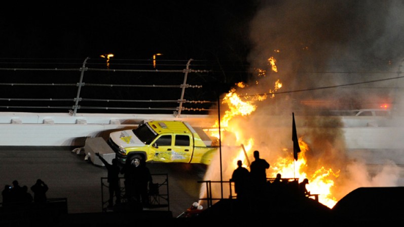 Personal de seguridad procede a intentar apagar el fuego tras accidente en carrera de automovilismo en el Daytona International Speedway, en Daytona Beach, Florida.