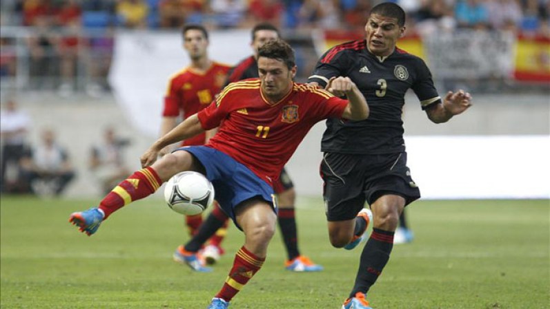 El centrocampista de la selección española, Koke (i), intenta controlar el balón ante el jugador del combinado de México, Carlos Salcido.