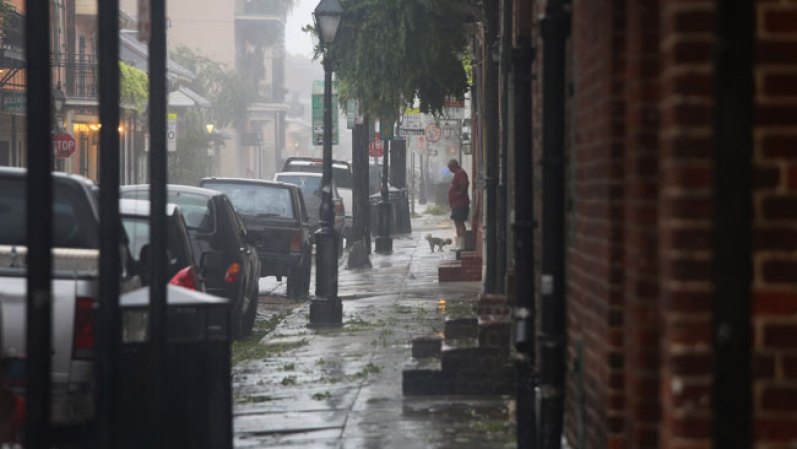 La gente visiblemente afectada por la neblina y la humedad que anunciaban la llegada de Isaac.