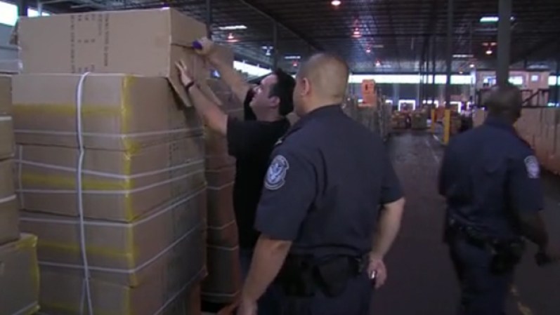 Agentes de Protección de Aduanas y Fronteras abren las cientos de cajas decomisadas con los juguetes chinos.