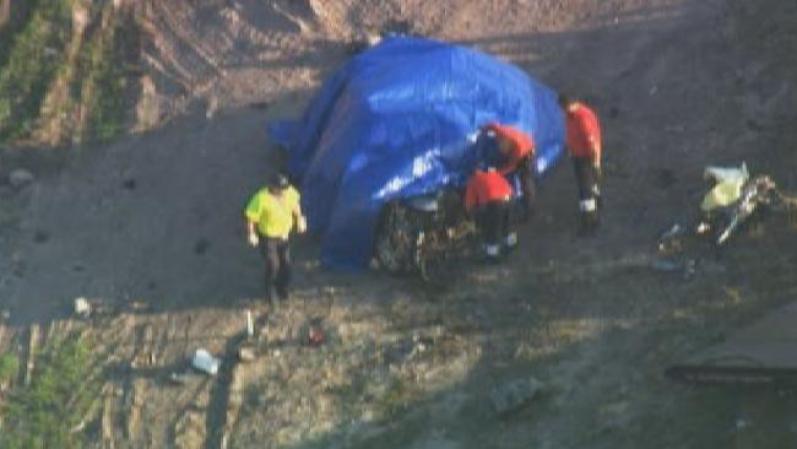 Vista aérea de los restos de la minivan cubiertos por la policía y los investigadores para preservar evidencia.