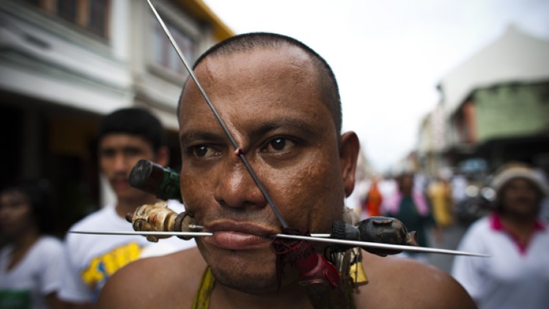 El festival vegetariano en Tailandia celebra la creencia de que la abstinencia de la carne durante el noveno mes lunar del calendario chino ayuda a obtener buena salud. El evento atrae a turistas que ven cómo los devotos se perforan las mejillas con objetos punzantes.