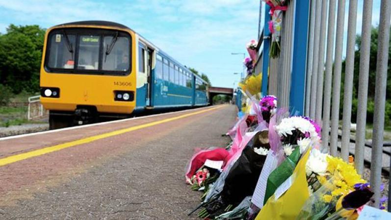 El tren de la estación local, donde decidió lanzarse y las ofrendas florales por la triste noticia.